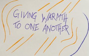 Purple text against a white background decorated with orange and purple lines, reading GIVING WARMTH TO ONE ANOTHER